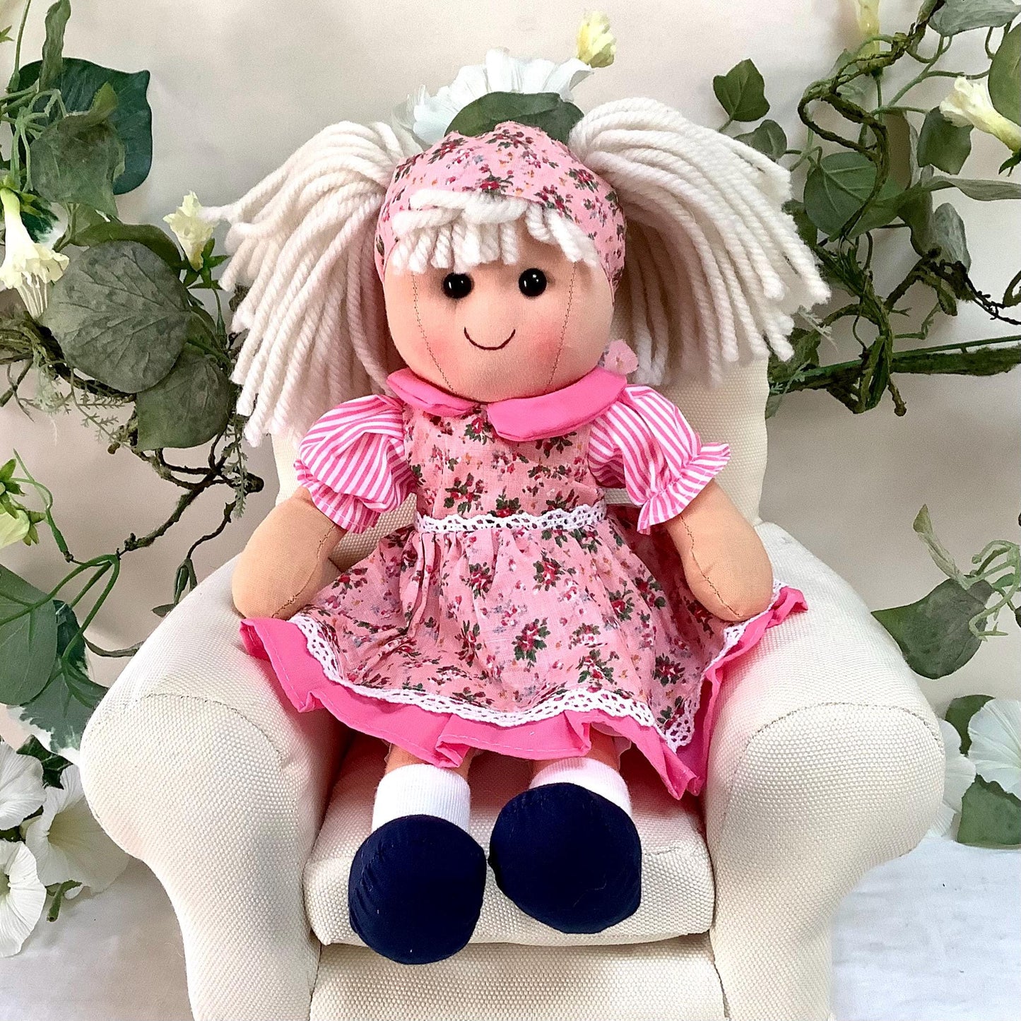 Vue rapprochée poupée tissu robe rose motifs fleuris Nina, jouet chiffon vintage 30 cm